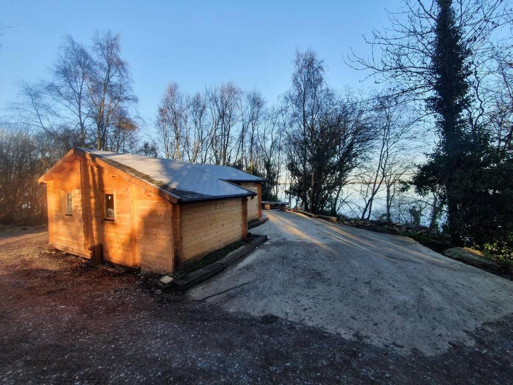 PortroeStunning log cabin on the lake的坐在路边的小棚子