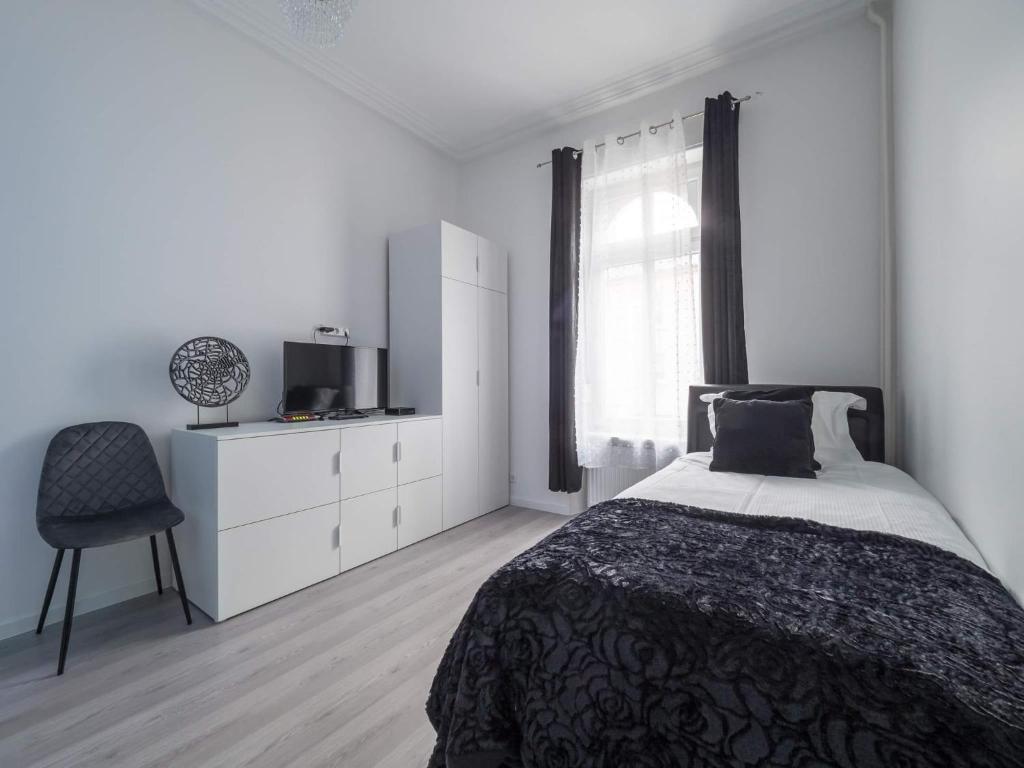 卢森堡EXECUTIVE SINGLE ROOM WITH EN-SUITE in GUEST HOUSE CITY CENTRE的白色卧室配有床和椅子
