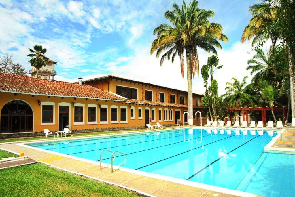 布加瓜达拉哈拉酒店的棕榈树建筑前的游泳池