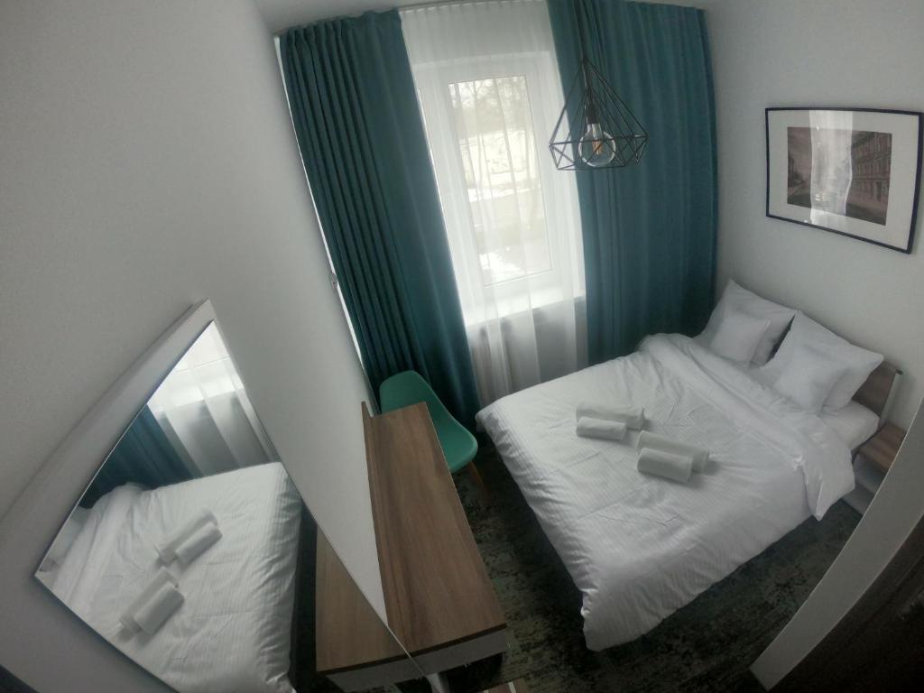 科沙林Stary Koszalin Hostel &amp; Hotel Services的配有2张床的小客房内的镜子