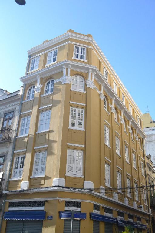 里约热内卢Sangha Urbana - hostel, yoga & meditação的街道上一座黄色建筑,设有白色窗户
