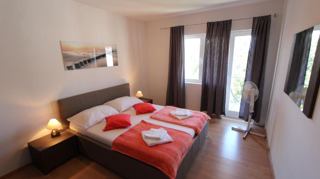 马林斯卡Apartments Stijak-Sorum的一间卧室配有一张带两个红色枕头的床