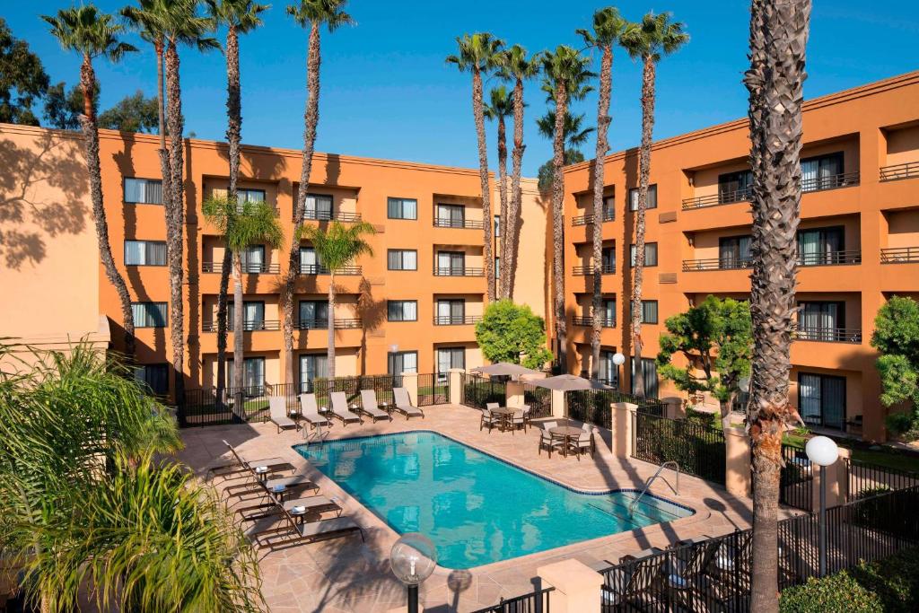 托伦斯洛杉矶托伦斯/南海湾万怡酒店的享有酒店外景,设有游泳池和棕榈树