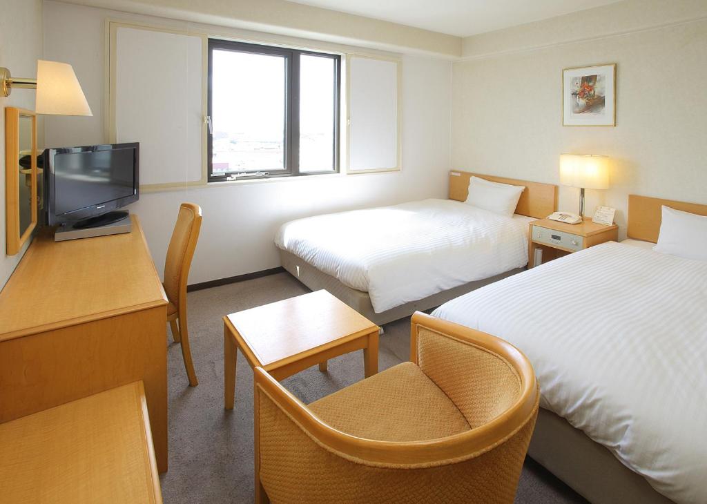 大川福冈大川微笑经济型酒店的酒店客房设有两张床和电视。