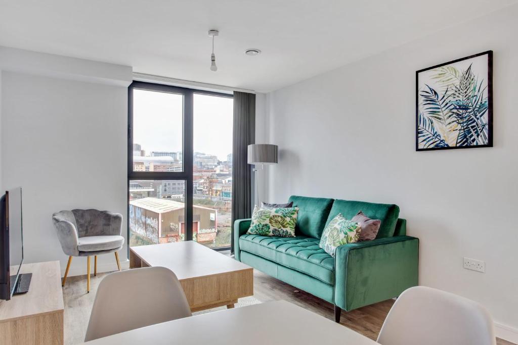 伯明翰Stunning 1br flat in Birmingham的客厅设有绿色沙发和大窗户