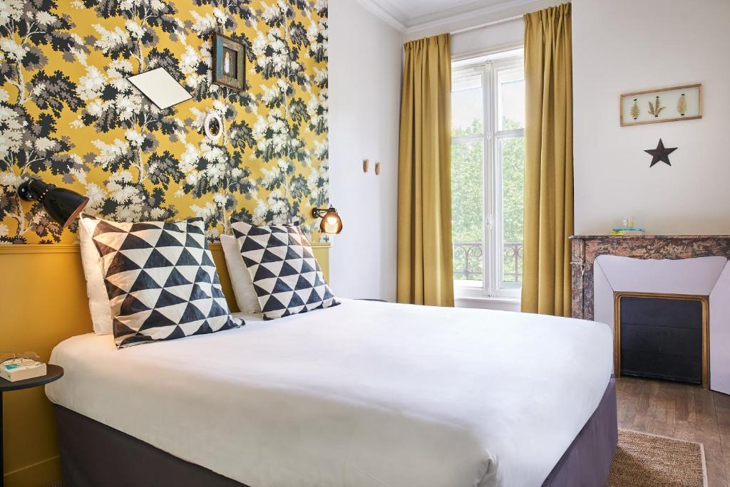 南希Hôtel Stanley by HappyCulture的一间卧室设有一张黄色墙壁的大床