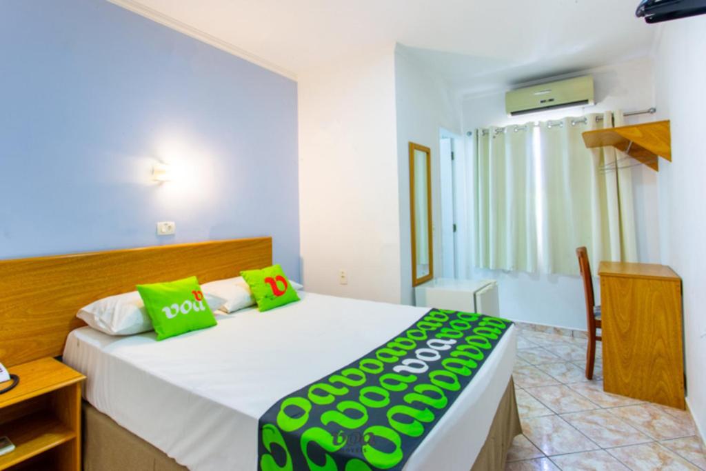 容迪亚伊VOA Convenience Hotel的一间卧室配有一张带绿色枕头的大床