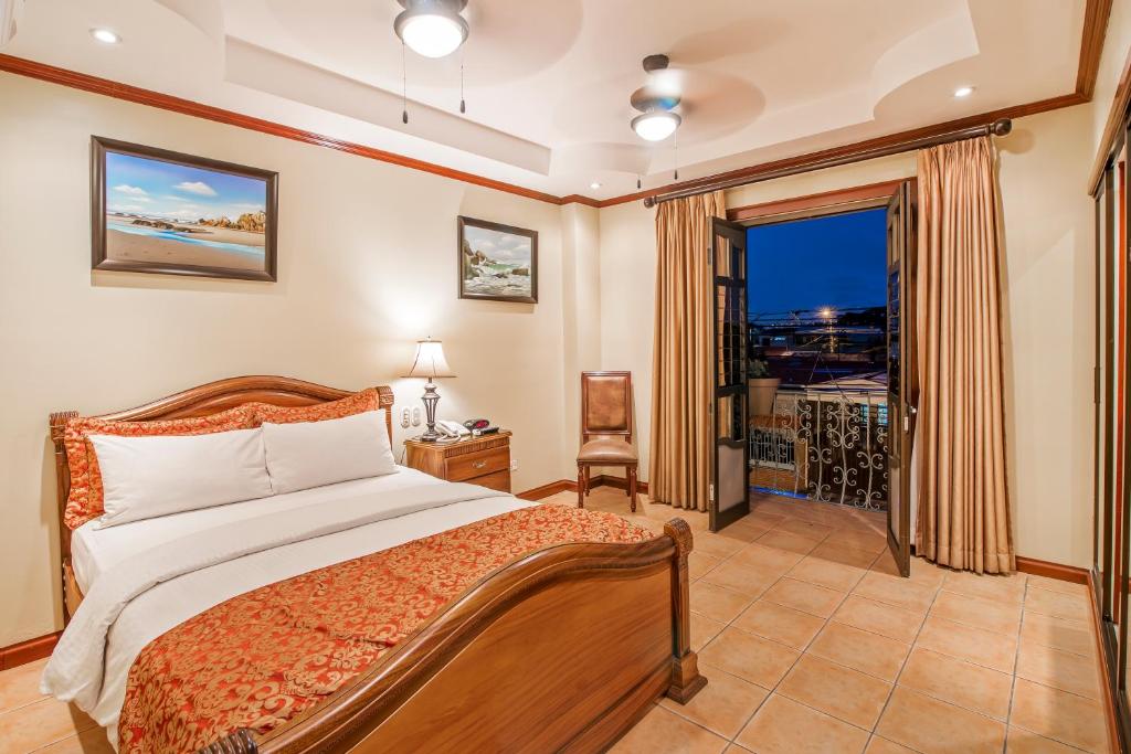 圣何塞Hotel Casa Roland San Jose的一间卧室设有一张床和一个大窗户
