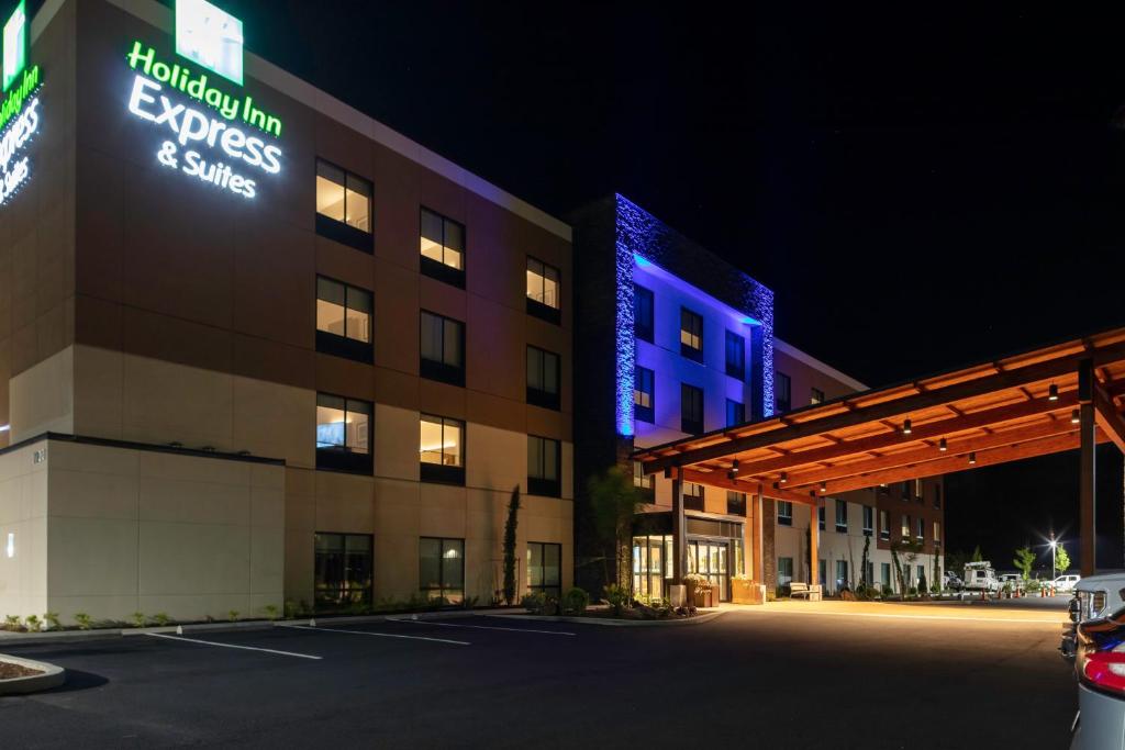 达尔斯Holiday Inn Express & Suites - The Dalles, an IHG Hotel的停车场有灯光标志的酒店