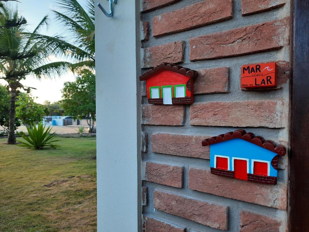 普拉杜Bangalô 7 na Praia de Guaratiba Prado Bahia的砖墙,两栋小房子