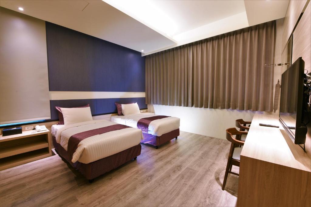 Shalu玉坤田商旅 的酒店客房设有两张床和一台平面电视。