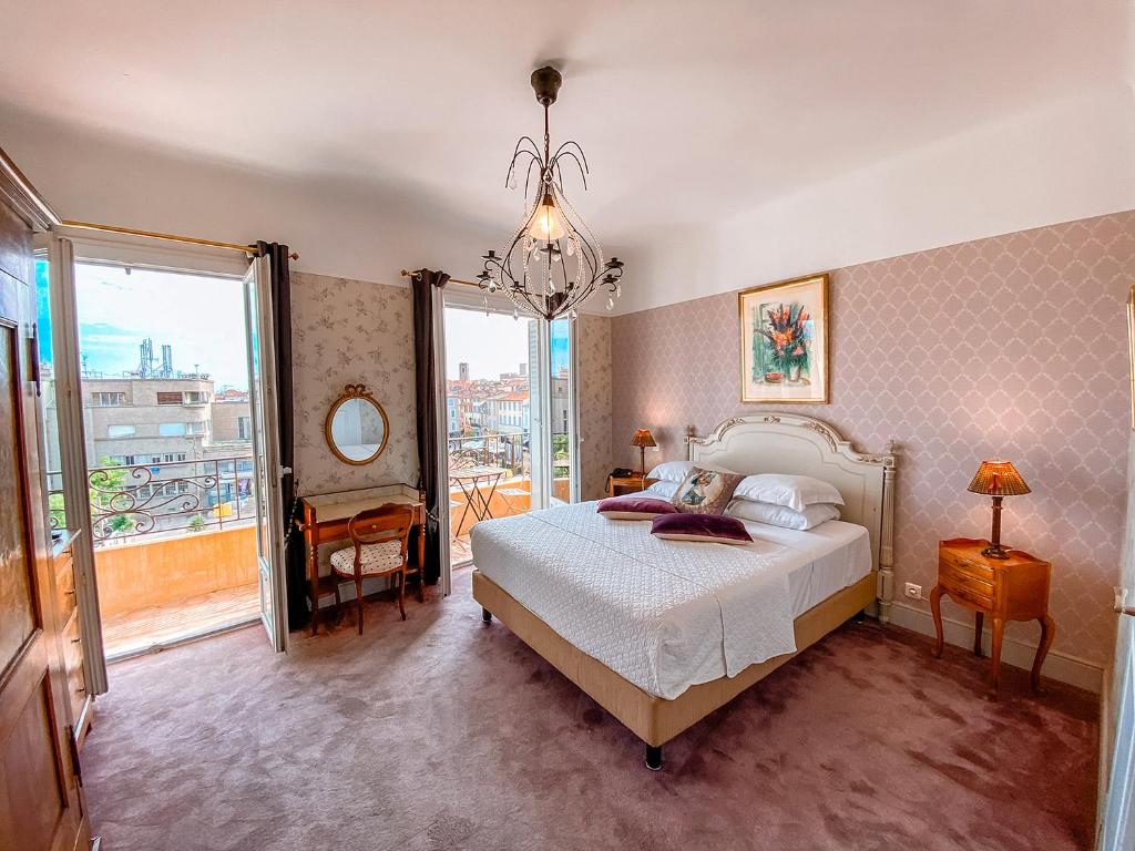 昂蒂布波斯蒂莱恩酒店的一间卧室设有一张床和一个大窗户