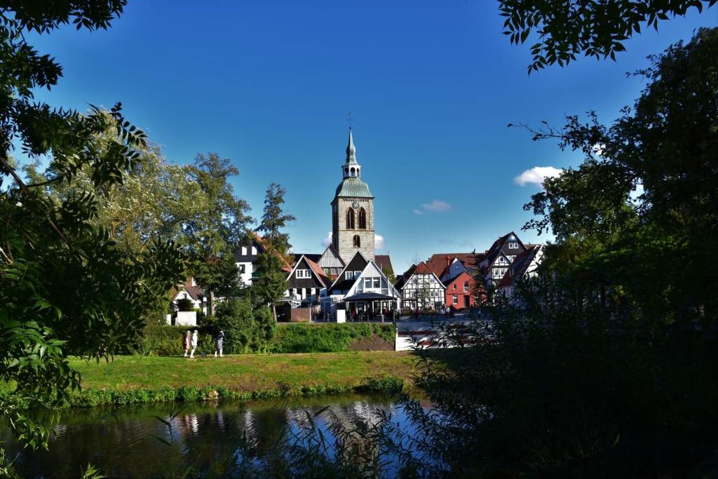 雷达-维登布吕克Ratskeller Wiedenbrück的一座有教堂、河流和树木的城镇