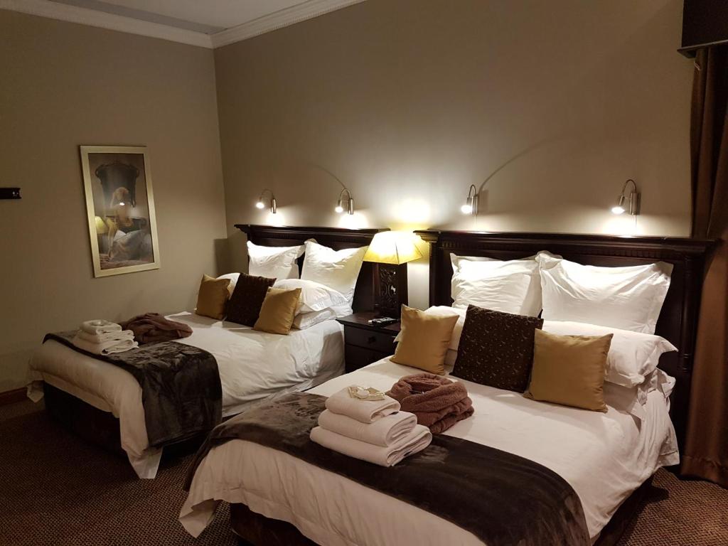 比勒陀利亚Cornerstone Guest Lodge的酒店客房,配有两张带毛巾的床