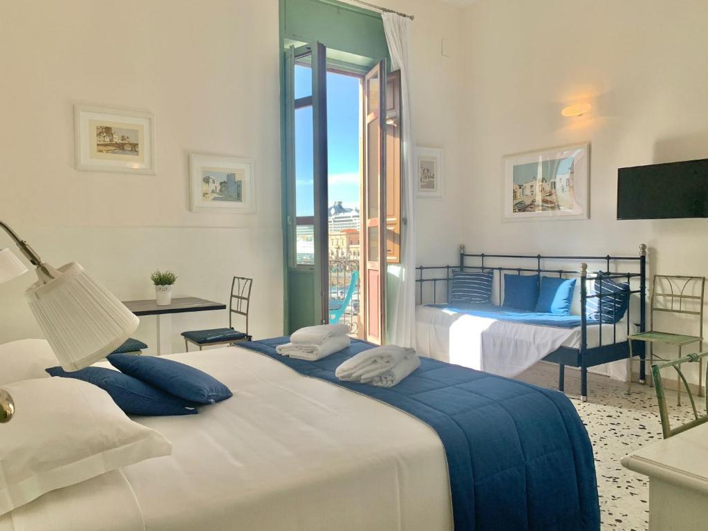 锡拉库扎珀斯塔酒店的一间卧室配有一张带蓝色枕头的大床