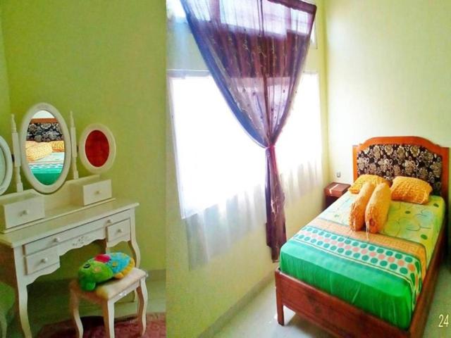 鲁滕D-Rima Homestay Ruteng的儿童卧室配有一张床和镜子