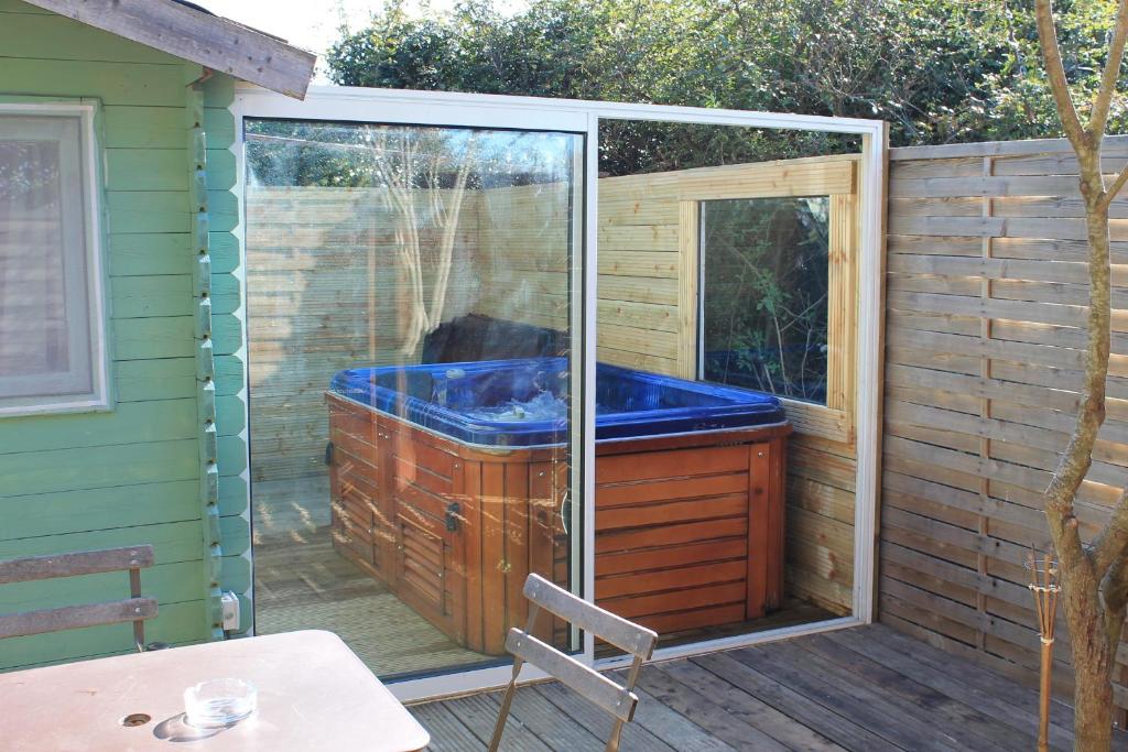 勒博塞Petit chalet climatisé avec jacuzzi privé的庭院中一个被屏蔽的按摩浴缸