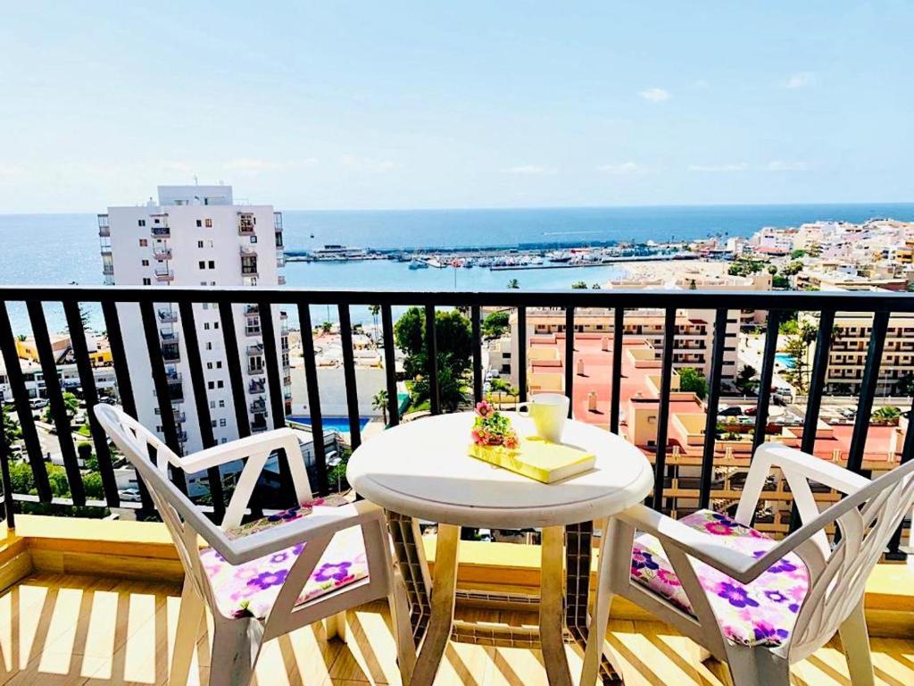洛斯克里斯蒂亚诺斯Amazing views to Los Cristianos Bay in Achacay的海景阳台上的桌椅