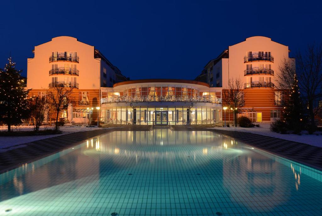 巴特乔京帝王酒店的一座建筑,在晚上前方有一个游泳池