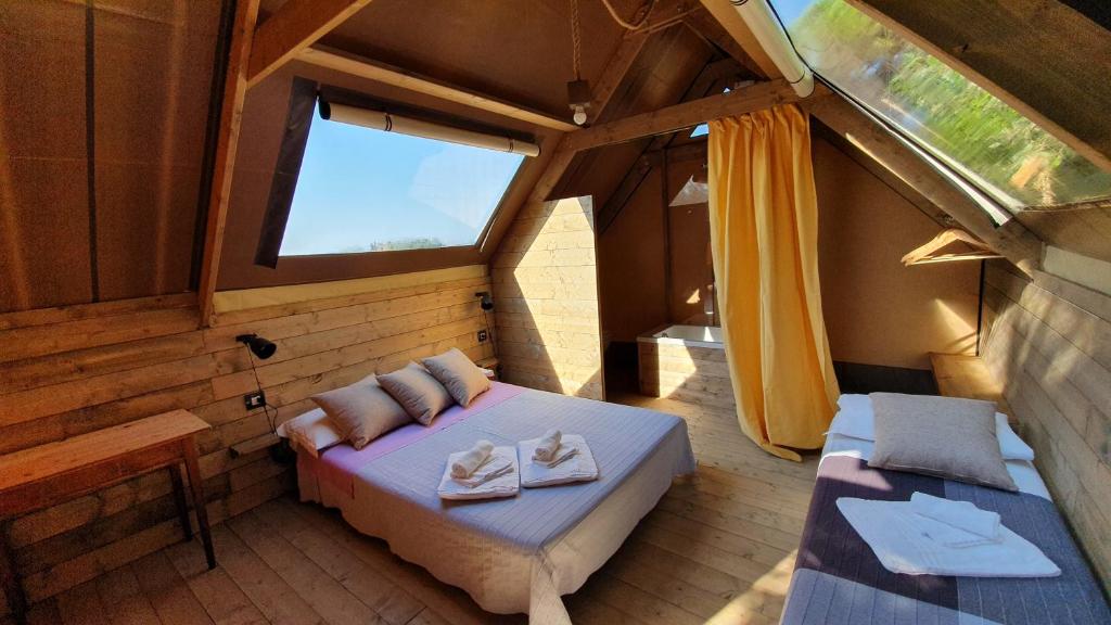 卡斯塔涅托卡尔杜奇Agricamping La Gallinella的一间卧室配有一张床,房间设有窗户