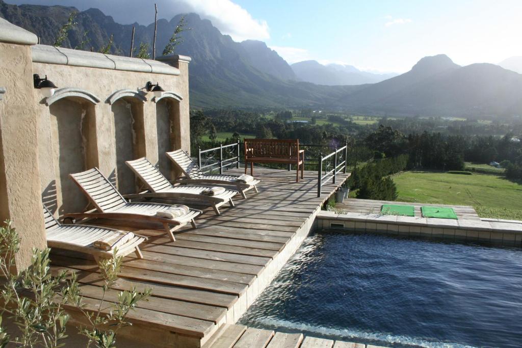 弗朗斯胡克Franschhoek Pass Villa的一个带躺椅的甲板和一个游泳池