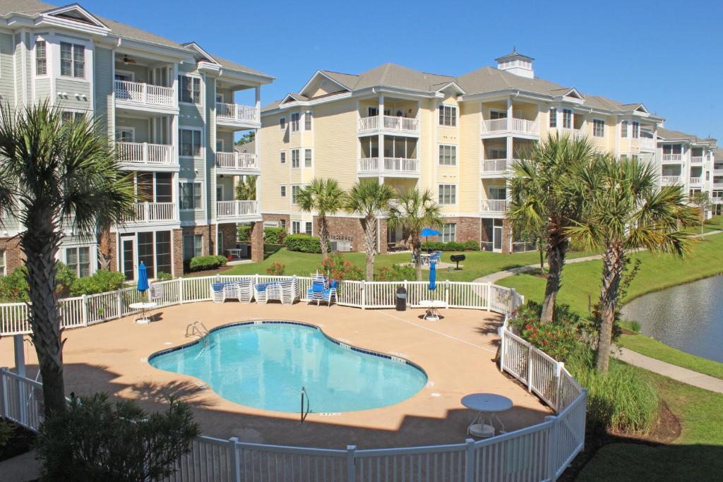 默特尔比奇马格诺利娅普安特棕榈度假别墅的公寓大楼前游泳池的图片
