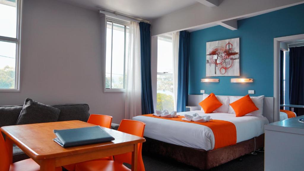 霍巴特海滨洛奇汽车旅馆的配有一张床、一张桌子和一张桌子的酒店客房