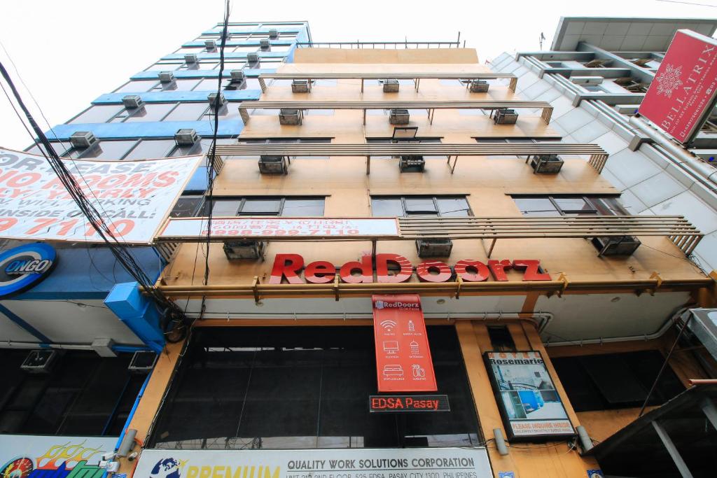 马尼拉RedDoorz at Hotel Rosemarie的一座高大的建筑,上面有红色的书签
