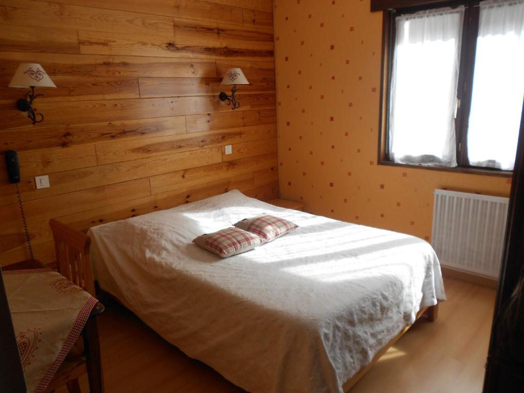 克松吕-隆日梅罗雷杜布亚酒店的卧室配有一张床铺,位于带木墙的房间内