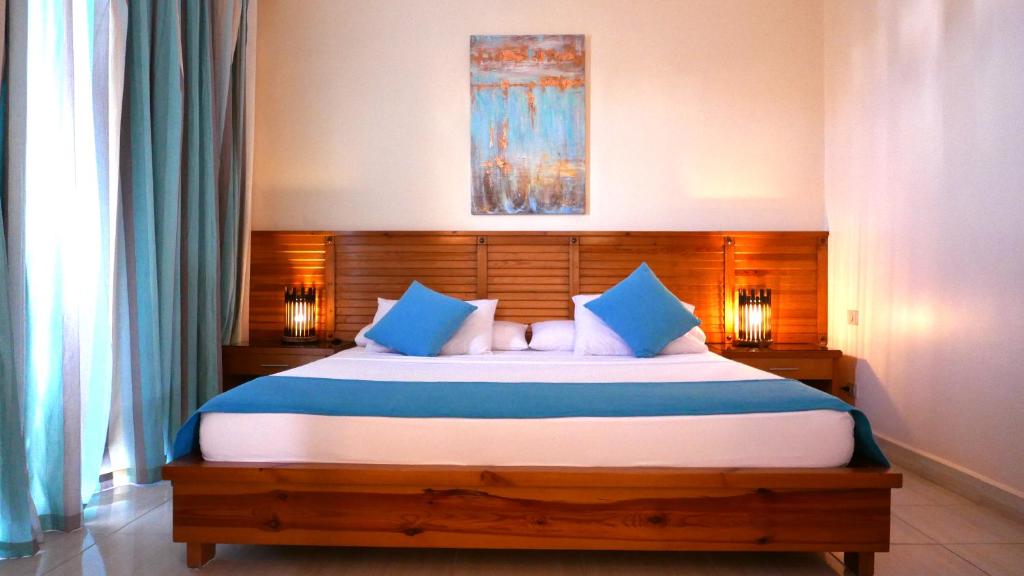 达哈布谢赫阿里达哈卜度假村的一间卧室配有一张带蓝色枕头的大床