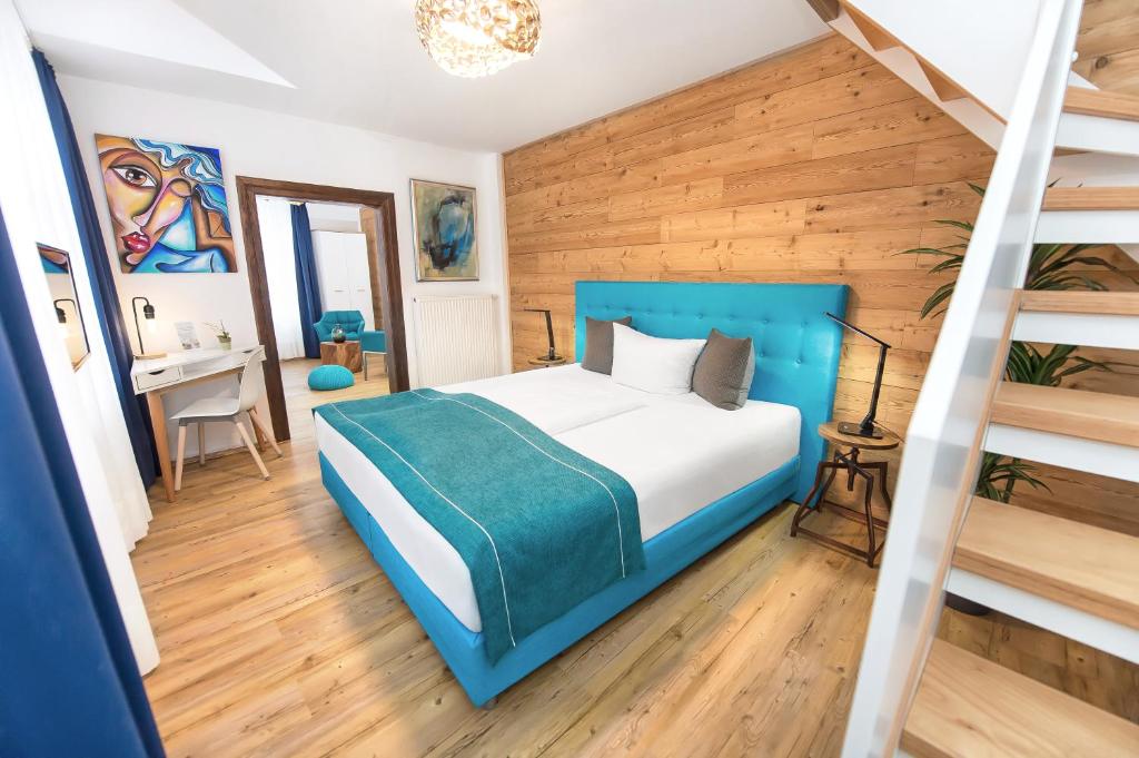 班贝格温伯酒店的一间卧室设有蓝色的床和楼梯。
