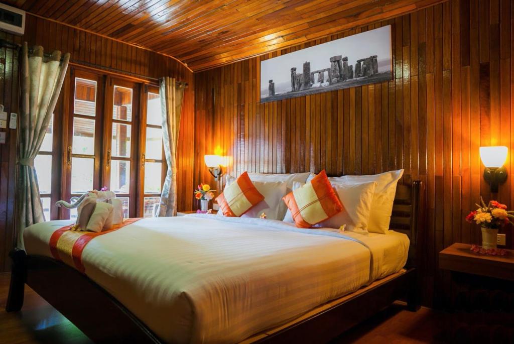 丽贝岛Chareena Beachside的一间卧室配有一张带木墙的大床