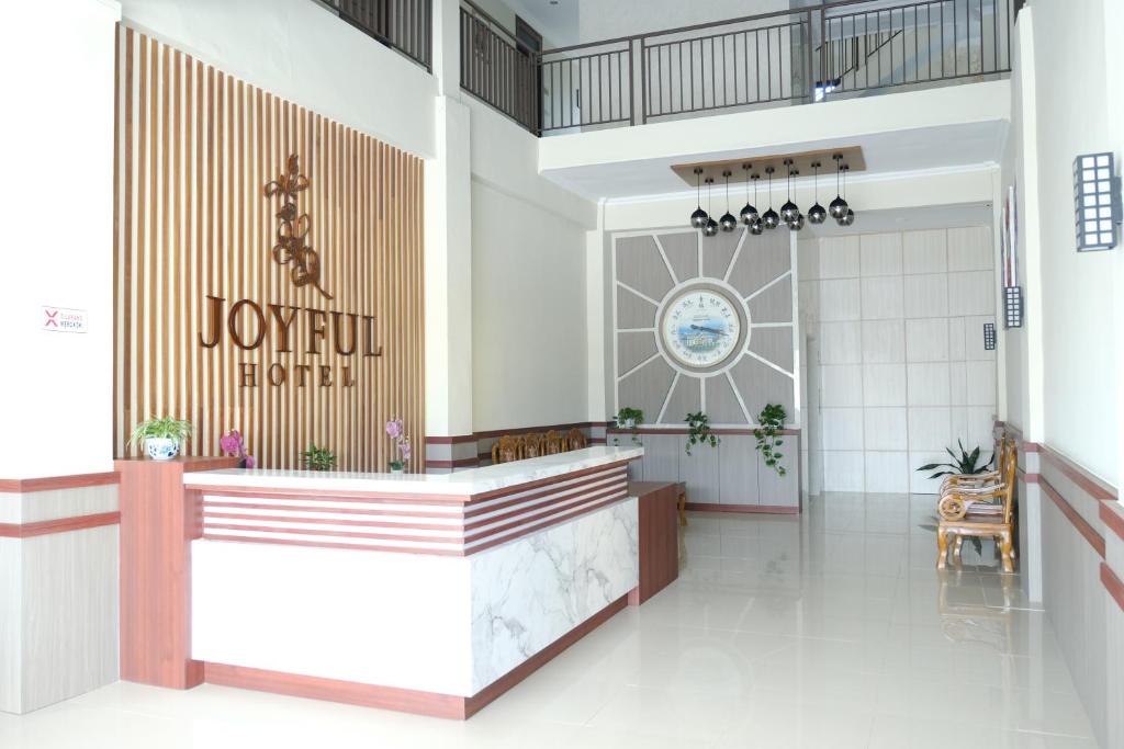 丹戎潘丹Joyful Hotel的乔利埃特酒店的大堂,墙上有标志