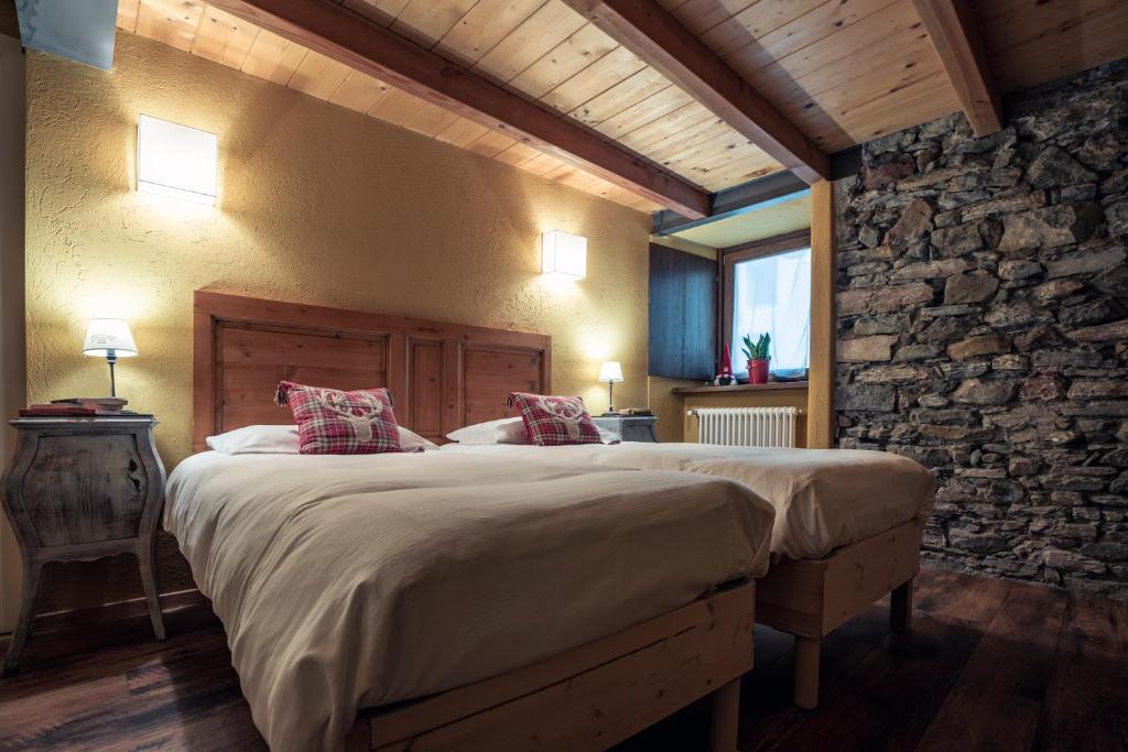 拉特乌伊莱里弗杰欧丽拉旅馆的一间卧室设有一张大床和石墙