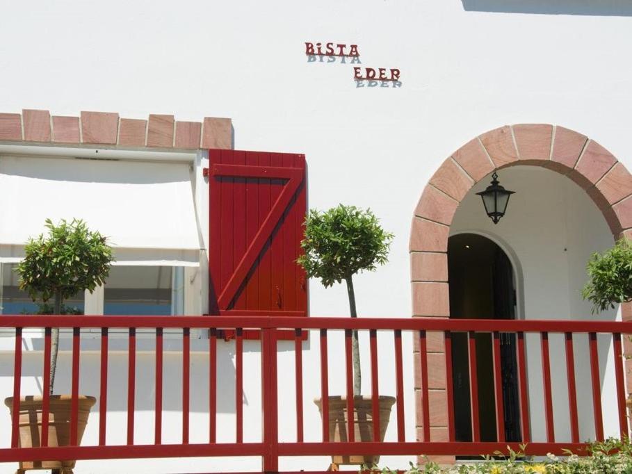 比达尔麦逊比斯塔埃德尔酒店的红色的大门,在一座有红色栅栏的建筑上