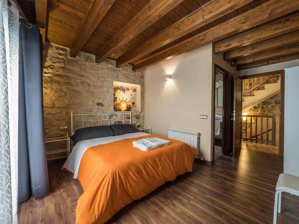 CaserasCasa rural Lo Niu的一间卧室配有一张带橙色毯子的床