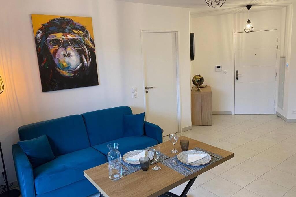 圣罗兰度瓦Deux pieces Moderne et Chaleureux的客厅配有蓝色的沙发和桌子