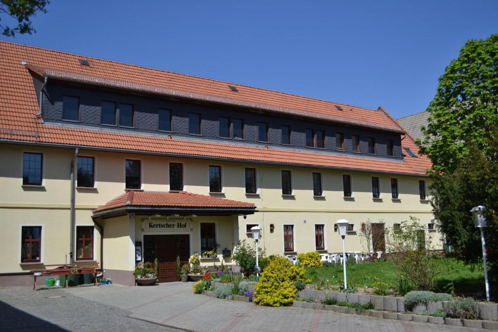 施默尔恩Landhotel Kertscher-Hof的一座白色的大建筑,有红色的屋顶