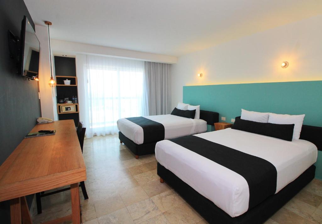 韦拉克鲁斯里沃利斯尔德酒店的酒店客房配有两张床和一张书桌
