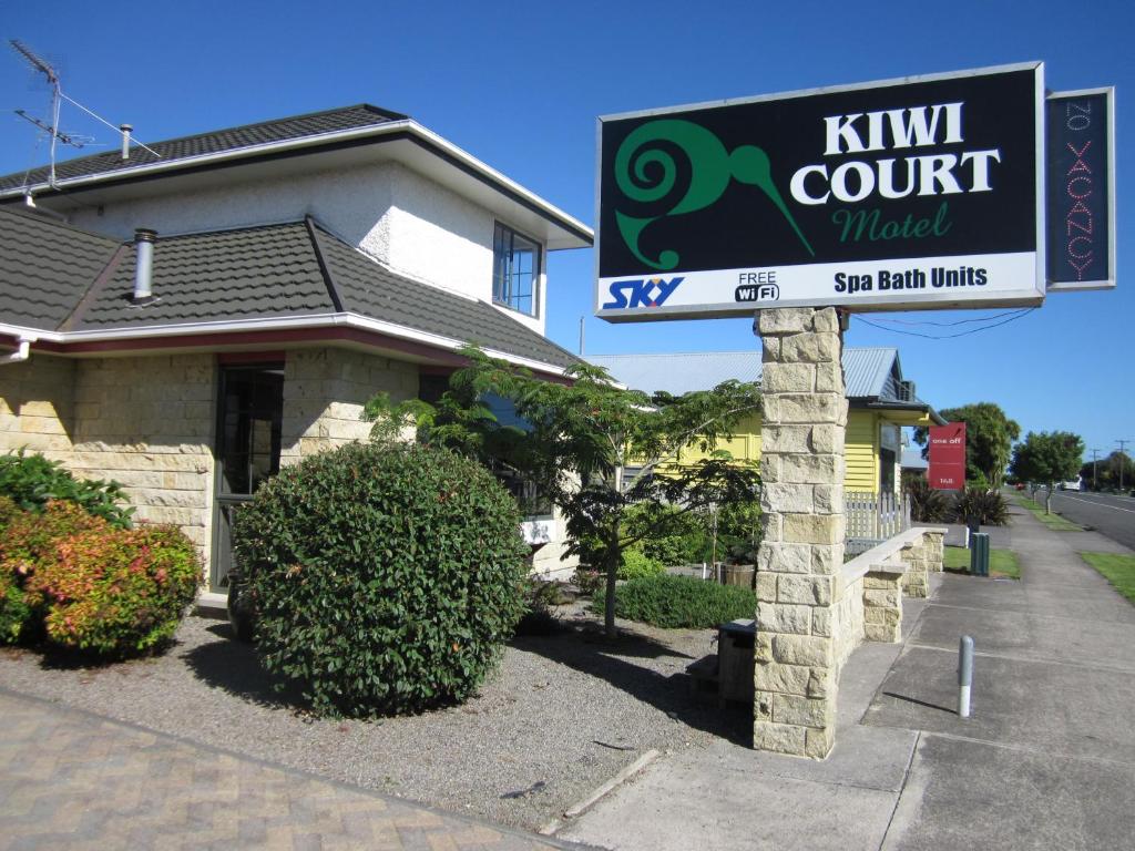 哈韦拉Kiwi Court Motel的 ⁇ 猴桃汽车旅馆的标志在房子前