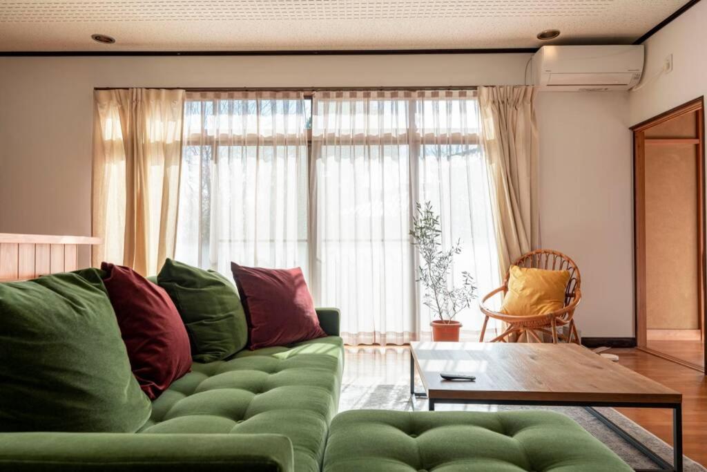 河津町懐-KAI-的客厅配有绿色沙发和桌子