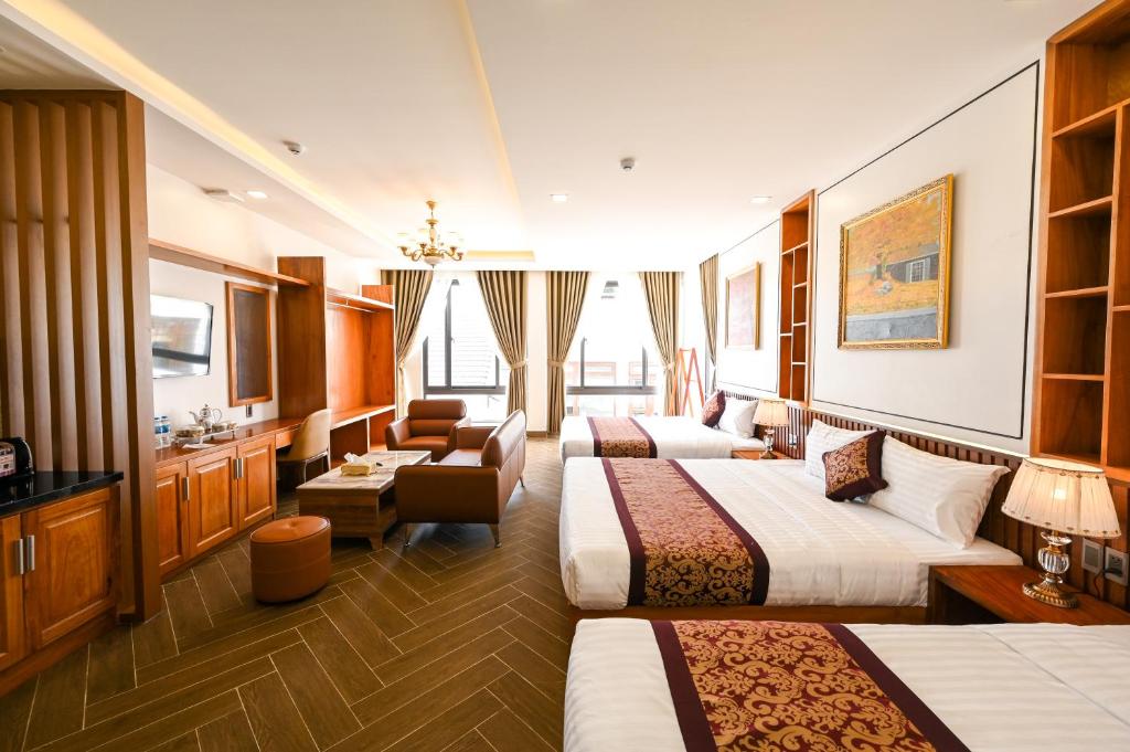 大叻La Fleur Premium Central Apartment Hotel的酒店客房设有三张床和一间客厅。