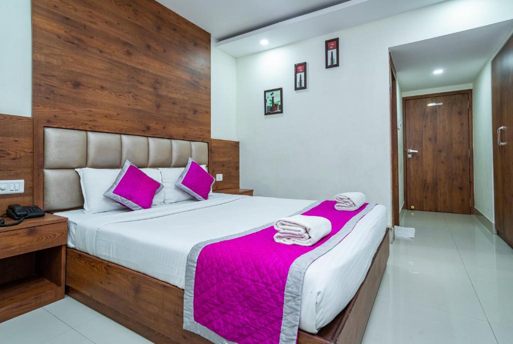 科泽科德Nexstay Crystal Residency的一间卧室配有一张带紫色枕头的大床
