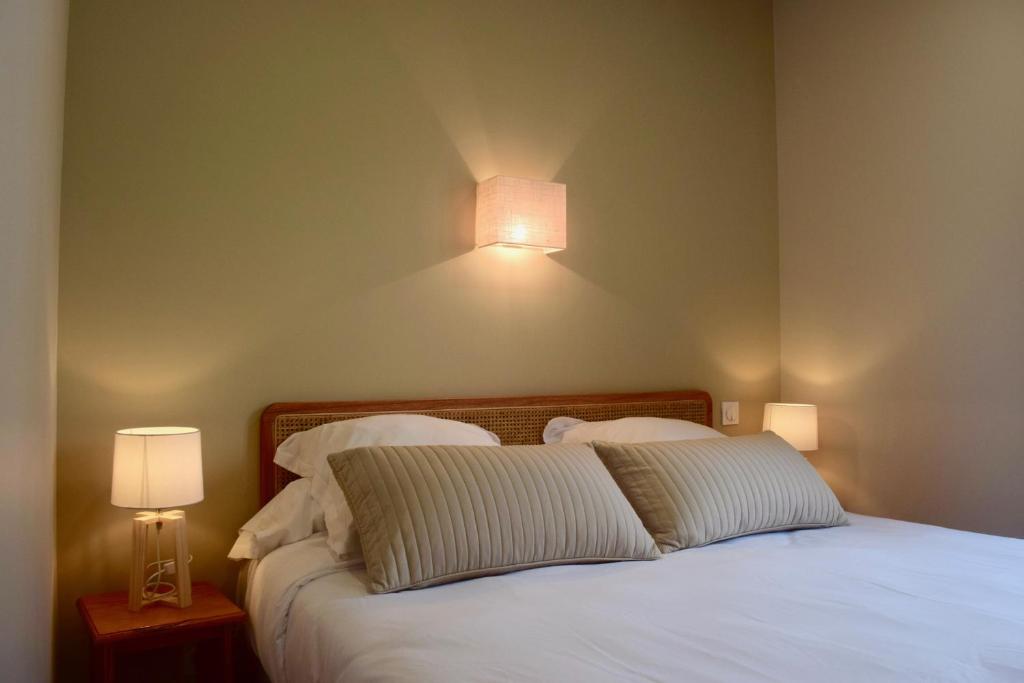 索伊茨Hôtel et appartements les platanes的一间卧室配有一张带白色床单和两盏灯的床。