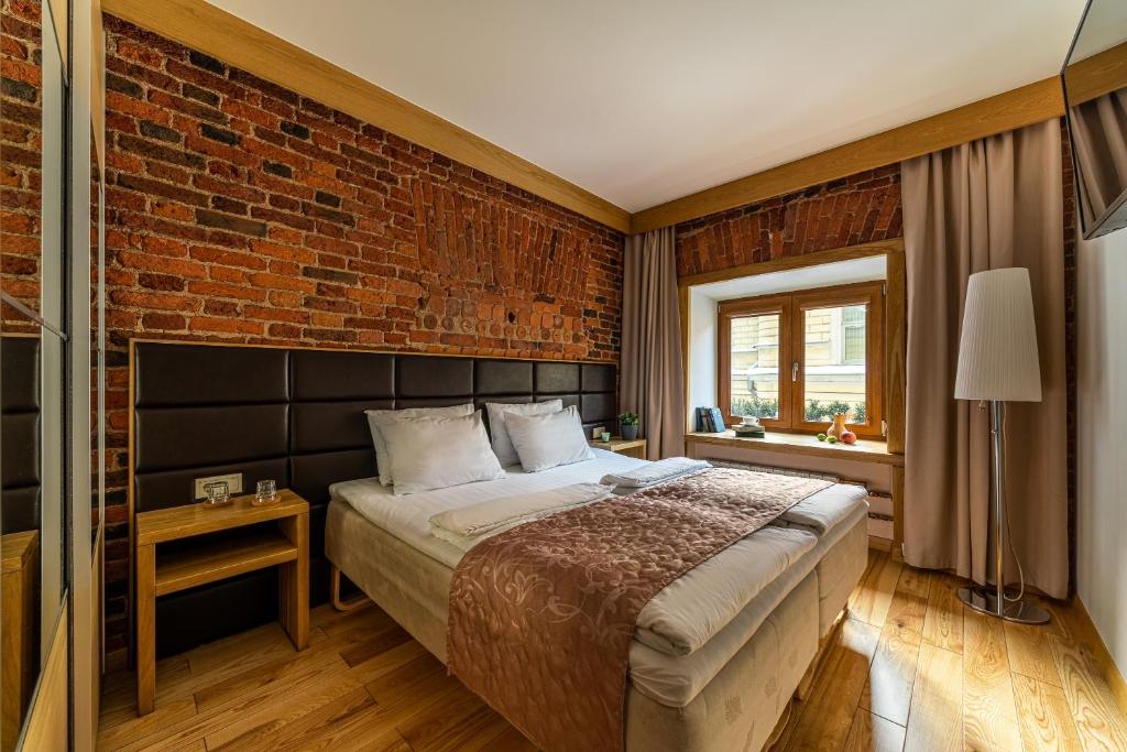 圣彼得堡Zen Hermitage的一间卧室设有一张床和砖墙