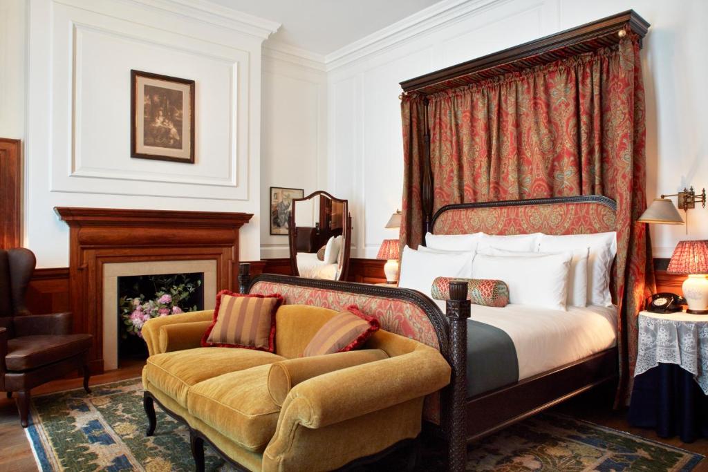 伦敦纳德酒店的一间卧室配有一张床、一把椅子和一个壁炉