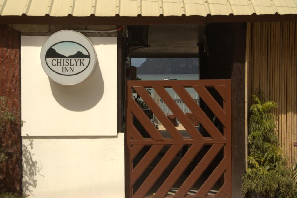 爱妮岛Chislyk Inn的木门房子的一侧的标志