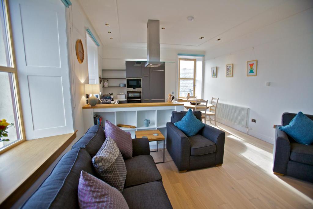 奥克尼Northlight Apartments - The Loom的带沙发和椅子的客厅以及厨房。