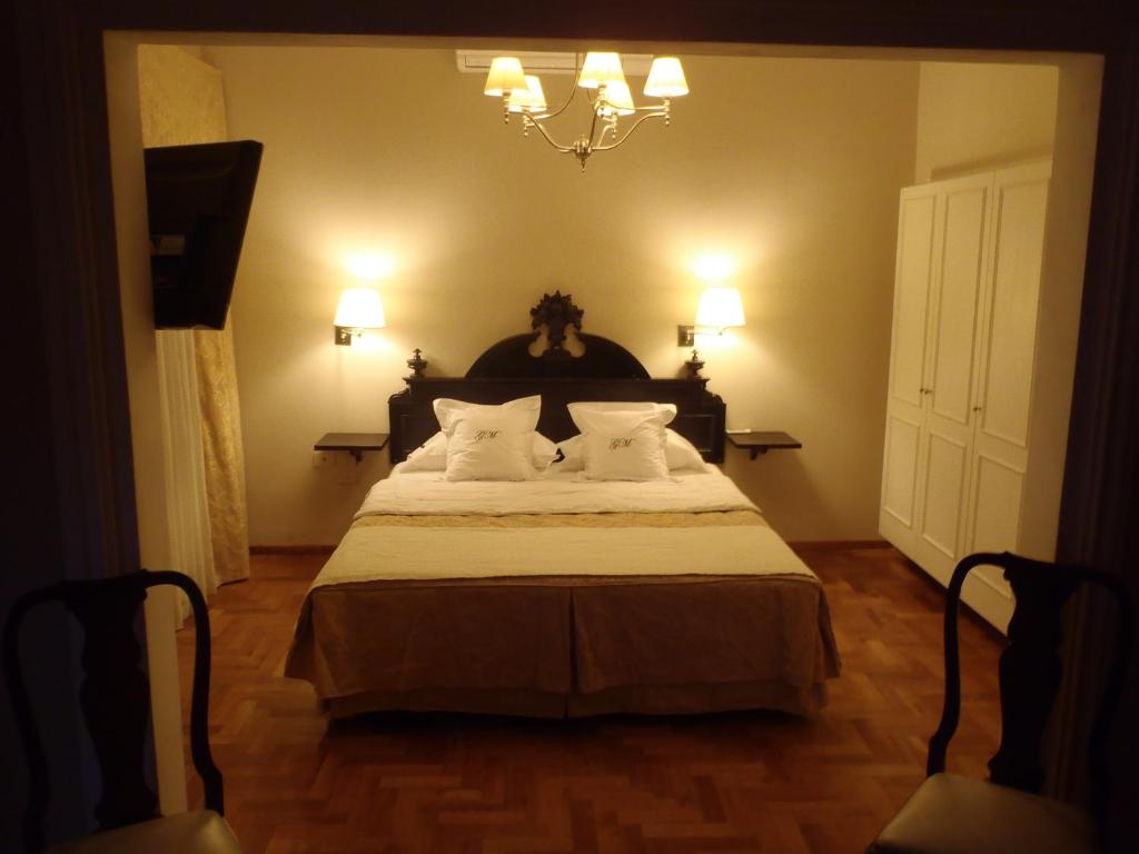 拉里奥哈GM Rooms Rental Suites的卧室配有带白色枕头和吊灯的床。