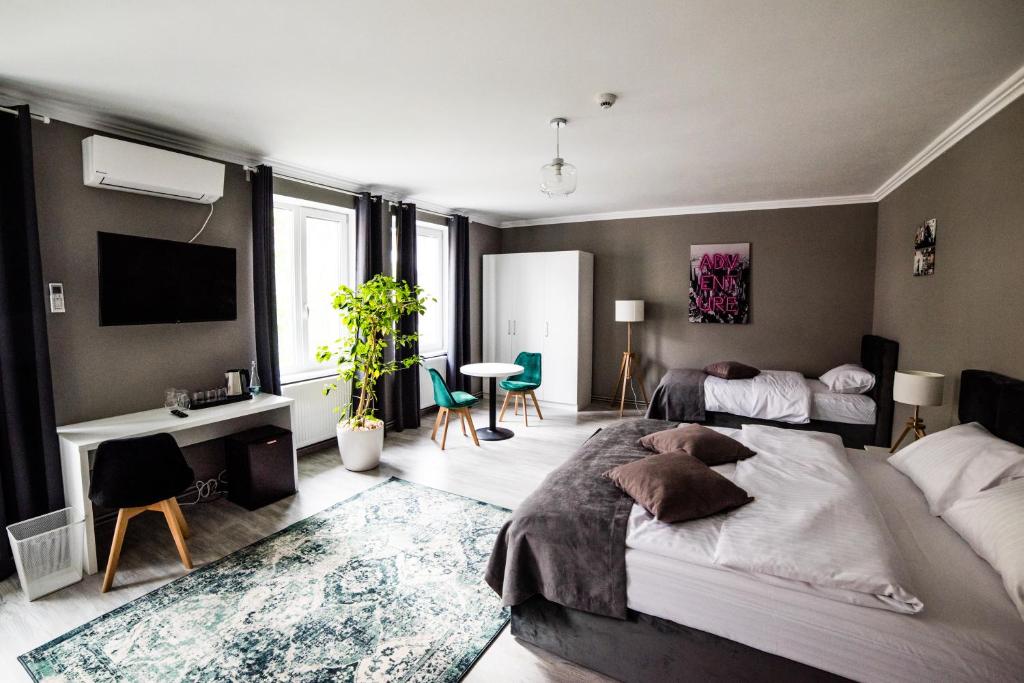 蒂米什瓦拉COMPLEX LIVING的一间卧室配有两张床、一张桌子和一台电视。